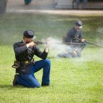 Soldiers at Fort Mackinac firing rifles.