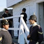 Costumed interpreters dressed as U.S. soldiers from the 1880s in front of the East Blockhouse at Fort Mackinac.