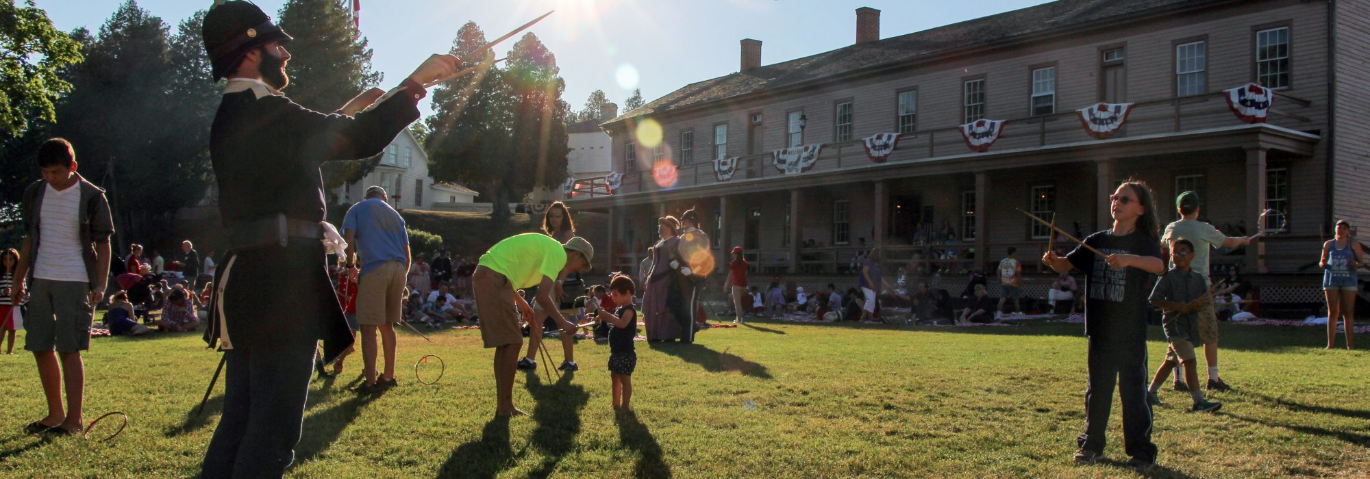 A Fort Mackinac soldier playing graces with a young guest.