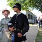 Costumed interpreters portraying a soldier and his wife from the 1880s taking a stroll at Fort Mackinac.