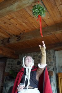 An interpreter hanging greenery at Michilimackinac