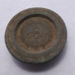 A one-ounce brass weight found in the archaeology dig at Colonial Michilimackinac.