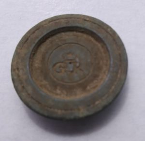 A one-ounce brass weight found in the archaeology dig at Colonial Michilimackinac.