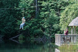 A person riding the zip line at Historic Mill Creek Discovery Park. 