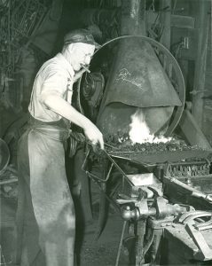Herbert Benjamin working at the blacksmith forge, taken in the 1950s. 