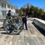 Historic Interpreters at Fort Mackinac loading a bronze cannon.