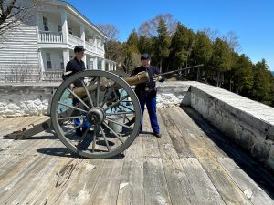 Historic Interpreters at Fort Mackinac loading a bronze cannon. 