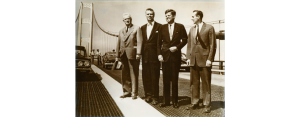 A photo of Prentiss Brown, G. Mennen Williams, John F. Kennedy, and an unidentified man on the Mackinac Bridge. 