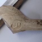 A picture of a fragment of a clay pipe with a Dutch company makers mark on it.