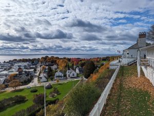 View from Fort Mackinac in the fall, featuring houses, cloud cover, and colorful leaves. 