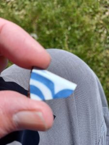 A fragment of a tin glazed bowl, with a blue and white pattern, found at Colonial Michilimackinac.