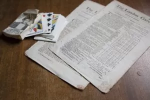 Under the Stamp Act of 1765, newspapers, playing cards, and other paper products were required to have an official stamp on them. Red tax stamps are visible on the bottom of these original newspapers on display at Michilimackinac.
