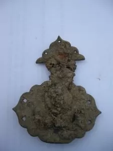 an intact lock from a small chest or similar item of furniture. It is made of brass, 2.75” long and 2.25” wide at its widest point.